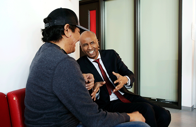 Minister Hussen speaks with a relative at Astum Api Niikinaahk about his experience in his new home.