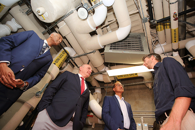 Le ministre Hussen, le ministre Boissonnault et le maire Sohi apprennent comment le bâtiment est chauffé et refroidi grâce à l’énergie géothermique, qui fait partie du bâtiment Net Zero Energy Ready (NZER).