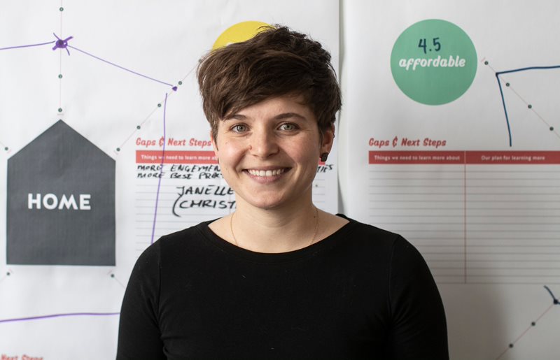 Paige Reeves devant des tableaux d’idées, avec des mots comme « abordable » et « chez-soi », créés dans le cadre du laboratoire de solutions sur l’avenir des logements inclusifs.