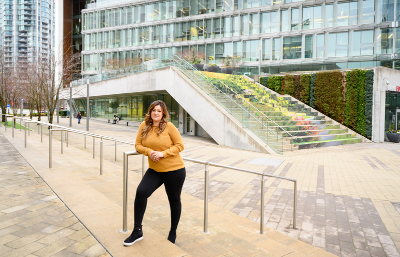 Krystal Dumais leaning on a handrail at the top of some steps outside Surrey City Hall.