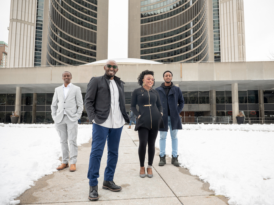 Kizito Musabimana and the  African-Canadian Housing Solutions Lab team standing in front of a building