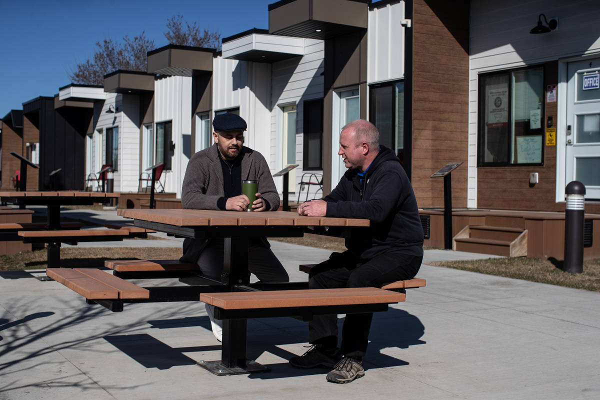 Jeremy, « diplômé » du programme Homes For Heroes, discute avec Arthur, qui vit actuellement dans l’ancien logement de Jeremy dans un village de Homes for Heroes d’Edmonton.